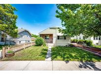 Charming home featuring a well-maintained front yard with a classic picket fence and blue skies at 2268 Jay St, Edgewater, CO 80214