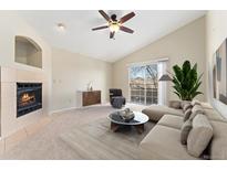 Bright living room featuring a fireplace, ceiling fan, and sliding glass doors to the outside at 8623 E Dry Creek Rd # 423, Englewood, CO 80112