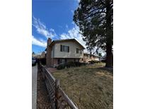 Charming two-story home featuring a well-maintained lawn, brick accents, and a rustic wooden fence at 2167 E 115Th Pl, Northglenn, CO 80233