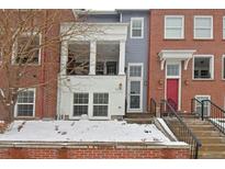 Charming townhome featuring brick and siding exterior, front porch, and well-maintained landscaping during winter season at 3401 N Xenia St, Denver, CO 80238