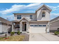 Charming two-story home with a covered porch and a two-car garage, and a well-maintained lawn at 27857 E 8Th Ave, Aurora, CO 80018