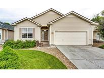 Charming single-story home with manicured lawn, covered entry, and attached two-car garage at 22026 Hill Gail Way, Parker, CO 80138