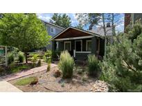 Charming home featuring lush landscaping, mature trees, and a welcoming brick pathway at 2033 S Ogden St, Denver, CO 80210