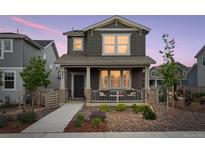 Charming two-story home featuring a welcoming front porch and landscaped front yard at 8057 Monte Vista Cir, Littleton, CO 80125