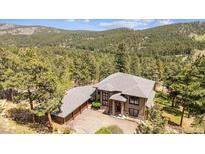 Beautiful home nestled in a serene wooded setting with an attached three-car garage at 20496 Stonewood Trl, Morrison, CO 80465