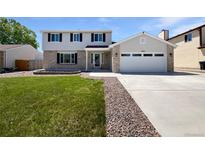 Inviting two-story home featuring a well-maintained lawn, brick accents, and an attached two-car garage at 5480 W 74Th Ave, Arvada, CO 80003