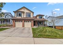 Charming two-story home with a well-manicured lawn and a two-car garage at 12551 W 84Th Cir, Arvada, CO 80005