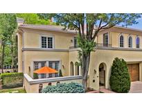 Elegant, light yellow two-story home with a tile roof, trimmed windows, and an orange umbrella on a small patio at 100 S University Blvd # 4, Denver, CO 80209