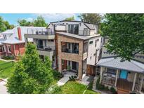 Beautiful modern home with multiple balconies, stone accents and a well-manicured front lawn at 1426 S Pearl St, Denver, CO 80210