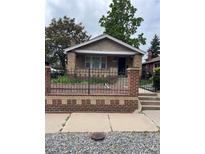 Charming bungalow with brick accents and a cozy, fenced front yard at 3036 W Clyde Pl, Denver, CO 80211