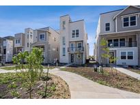 Modern townhome shows attractive multi-story design, sidewalk, and lawn space at 1257 Rhett Dr, Erie, CO 80026