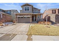 Charming two-story home with stone accents, a two-car garage, and a well-manicured lawn at 1043 S Fultondale Ct, Aurora, CO 80018