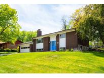 Charming brick home with a well-maintained lawn, bright blue front door, and attached garage at 1757 S Van Dyke Way, Lakewood, CO 80228