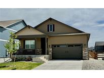 Charming one-story home featuring a covered porch, attached garage and nicely manicured front lawn at 222 Fox St, Bennett, CO 80102