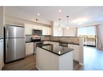 Bright kitchen features stainless steel appliances, granite countertops, island, and an open floorplan at 1785 Morrison Ct, Superior, CO 80027