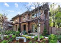 Two story brick home features manicured landscaping and a charming bench out front at 318 Adams St, Denver, CO 80206