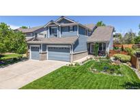 Charming blue two-story home with a manicured lawn and a three-car garage offering great curb appeal at 4826 S Ireland St, Aurora, CO 80015