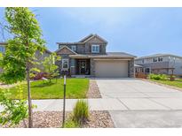 Beautiful two-story home with stone accents, well-manicured lawn, and a two-car garage at 9350 Dunraven St, Arvada, CO 80007