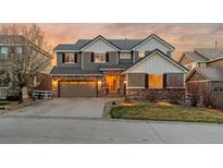 Charming two-story home with a brick and siding facade, garage, and well-manicured lawn at sunset at 1609 S Catawba Cir, Aurora, CO 80018