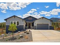 Beautiful two-tone home with an attached garage and landscaped front yard and mountain views at 4745 Mesa Top Dr, Monument, CO 80132