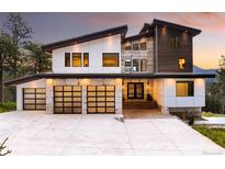 Striking modern home showcasing a three-car garage and unique architectural details at 29822 Troutdale Scenic Dr, Evergreen, CO 80439