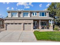 Charming two-story home featuring a brick and tan exterior, a two-car garage, and a well-manicured front lawn at 9531 Desert Willow Way, Highlands Ranch, CO 80129