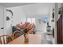 Bright living room featuring vaulted ceiling, fireplace, and view of townhome community at 970 S Dawson Way # 9, Aurora, CO 80012