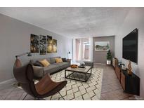 Inviting living room with comfortable seating, stylish decor, and a sliding glass door to a private patio at 2500 S York St # 115, Denver, CO 80210