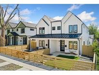 Charming two-story home featuring white siding, black accents, and a well-maintained front yard with a wooden fence at 2426 Ames St, Edgewater, CO 80214