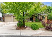 Charming home featuring a well-maintained lawn, mature landscaping, and a classic exterior at 7579 Jay Ct, Arvada, CO 80003