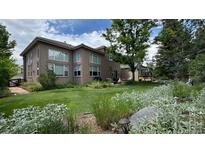 Expansive backyard with lush green lawn, mature landscaping, and patio area, perfect for outdoor living at 6584 S Sedalia St, Aurora, CO 80016