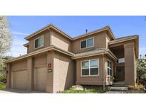 Two-story home with tan stucco exterior, two-car garage, well-manicured lawn, and front entrance at 6584 S Sedalia St, Aurora, CO 80016