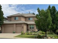 Charming two-story home with a three car garage, lush landscaping, and a beautifully tiled roof at 6584 S Sedalia St, Aurora, CO 80016