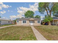 Charming single-story home featuring a well-maintained lawn and a welcoming walkway to the front door at 1023 S Alcott St, Denver, CO 80219