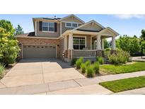 Charming two-story home with a covered front porch, stone accents, and a well-maintained front yard and driveway at 13322 Meadow Park Ln, Broomfield, CO 80020