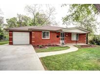 Charming single story brick home featuring a paved walkway, attached garage, and well-maintained lawn at 6340 Quay St, Arvada, CO 80003