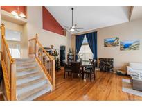 Bright dining room featuring hardwood floors, a decorative ceiling fan, and ample natural light from a large window at 13277 Elizabeth St, Thornton, CO 80241