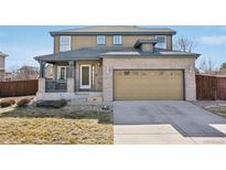 Charming two-story home with a brick facade, covered porch, and two-car garage at 2490 S Jebel Way, Aurora, CO 80013