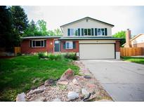Charming two-story home featuring a brick facade, attached two-car garage, and a well-maintained front yard at 1552 S Fairplay Way, Aurora, CO 80012