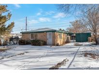 Ranch style home with snow-covered yard at 950 S Leyden St, Denver, CO 80224