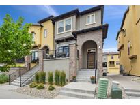 Attractive townhome with brick accents, concrete steps, and a cozy front porch in a well-maintained neighborhood at 2505 S Orion St, Lakewood, CO 80228