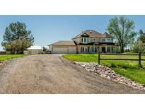 Charming home featuring a large yard, gravel driveway, and a three-car garage, with a separate garage in the back at 8184 S Ireland Way, Aurora, CO 80016