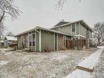 A charming two-story home with a rock facade and a snowy front yard on a cloudy day at 10001 E Evans Ave # 81C, Aurora, CO 80247