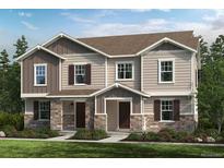 Charming two-story townhome featuring stone accents, siding, and a well-manicured lawn at 20877 E 59Th Ave, Aurora, CO 80019