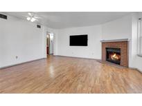 Living room with brick fireplace and wood floors at 979 S Miller St # 202, Lakewood, CO 80226