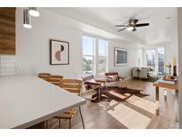 Bright living room featuring hardwood floors, modern furnishings, and abundant natural light from large windows at 1810 Irving St # 8, Denver, CO 80204