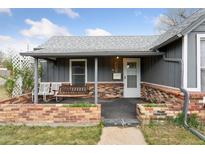 Charming home featuring a covered front porch with swing and brick accents at 4595 S Fox St, Englewood, CO 80110