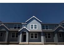 Charming two-story townhouse with gray siding, white trim, and bright windows under a deep blue sky at 17137 W 91St Ln, Arvada, CO 80007