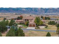Expansive home with a tile roof and mountain views, plus a circular driveway and two-car garage at 8871 Aspen Leaf Ct, Littleton, CO 80125