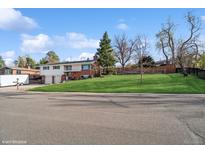 Charming two-story home with a well-manicured lawn and mature trees at 11600 W 31St Pl, Lakewood, CO 80215